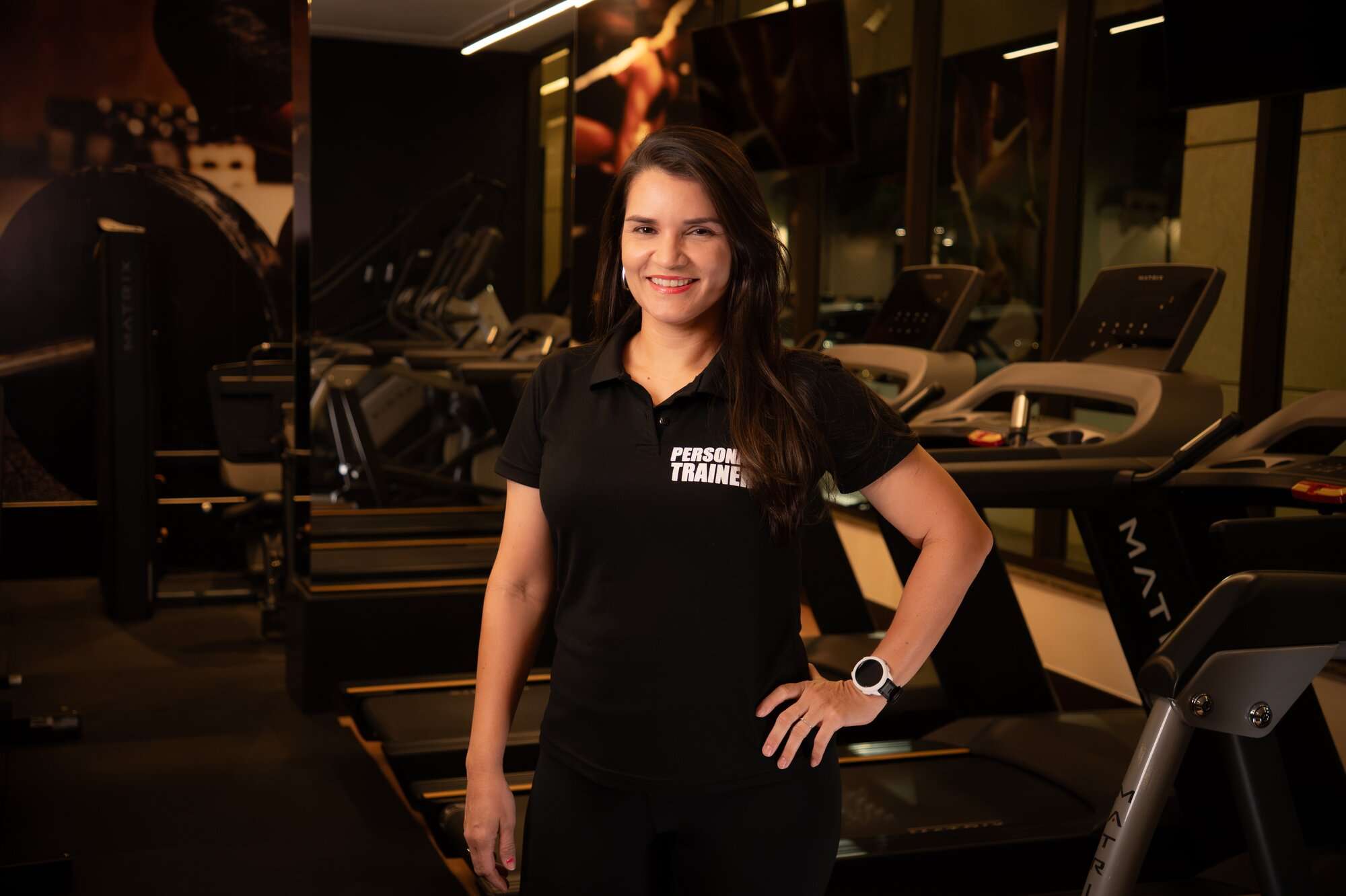 Licia Furtado, personal trainer em Brasília, com a mão na cintura na academia