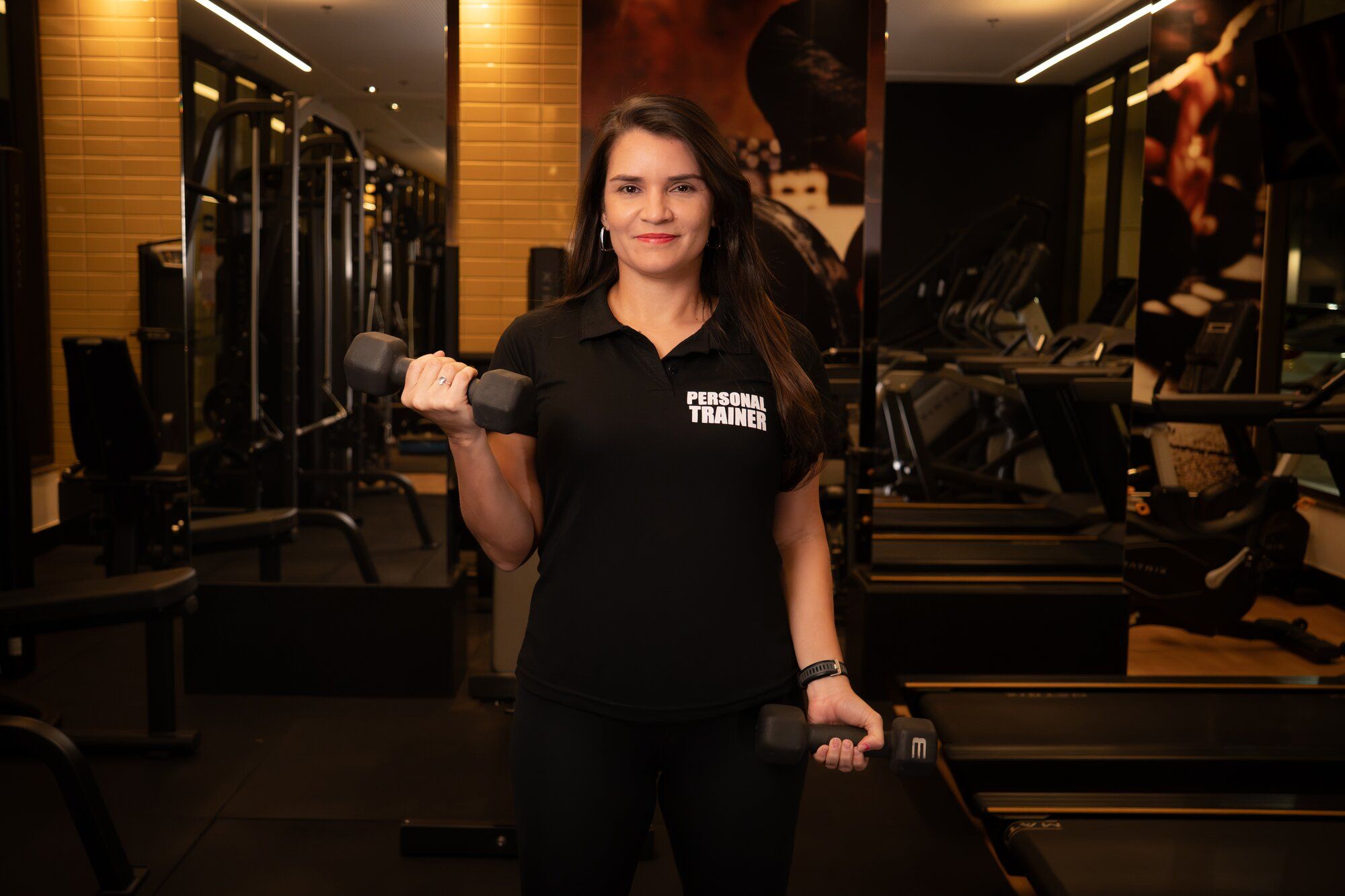 Licia Furtado segurando dois halteres no treino de força